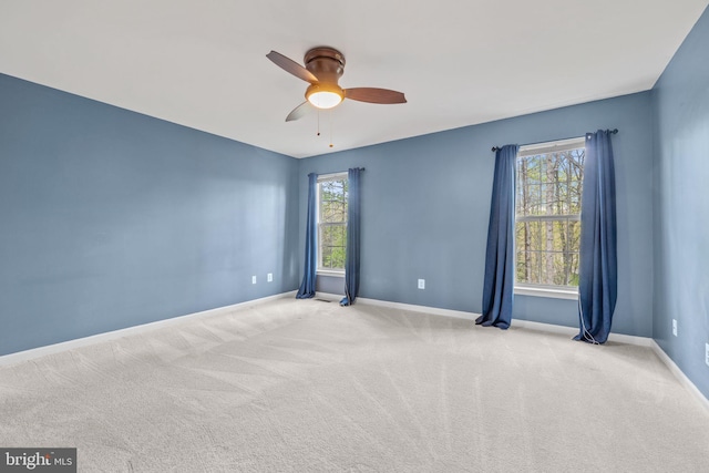 empty room with a ceiling fan, a healthy amount of sunlight, and carpet flooring