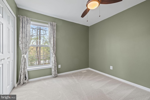 unfurnished room featuring baseboards, carpet, and ceiling fan