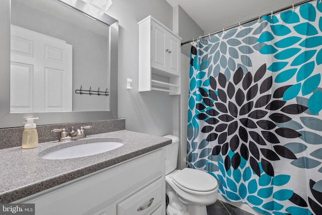 full bathroom featuring toilet, curtained shower, and vanity