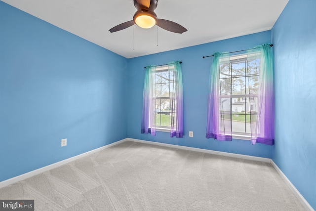spare room featuring baseboards, carpet, and a ceiling fan