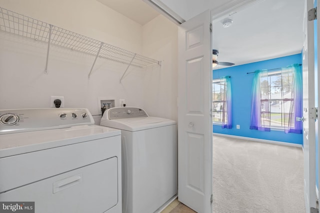 clothes washing area with laundry area, baseboards, washer and dryer, and light carpet