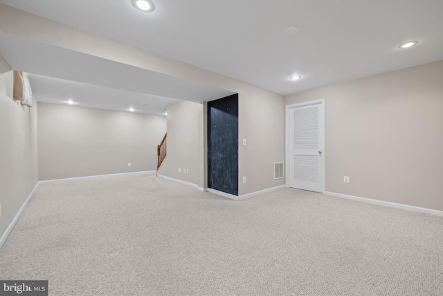 finished below grade area featuring visible vents, recessed lighting, baseboards, and light carpet