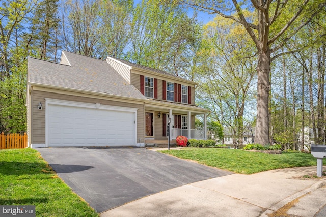 view of front of property featuring aphalt driveway, fence, covered porch, a front yard, and an attached garage
