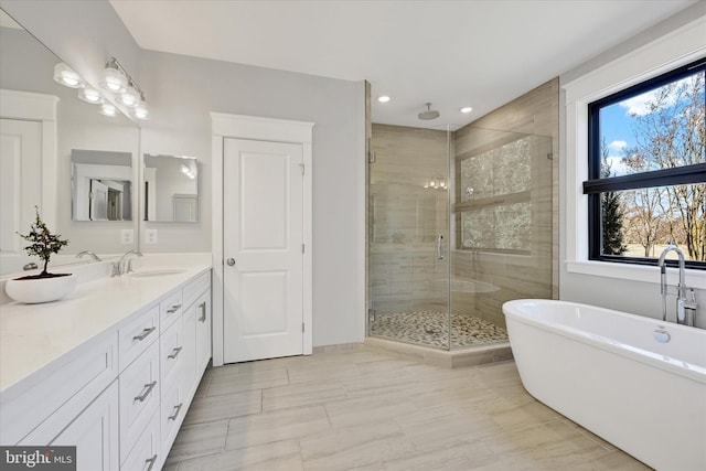 full bath featuring vanity, recessed lighting, a shower stall, and a freestanding bath