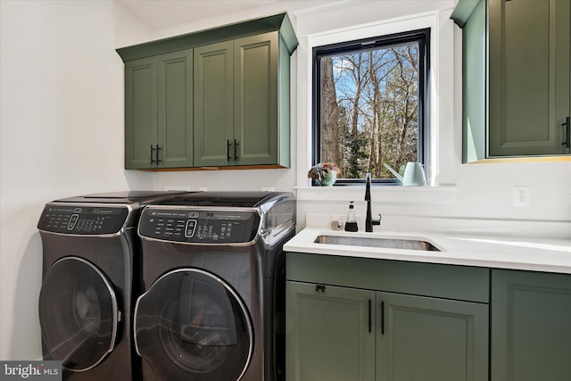 washroom with a sink, cabinet space, and separate washer and dryer