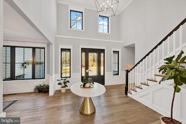 entrance foyer with wood finished floors, stairway, and a chandelier