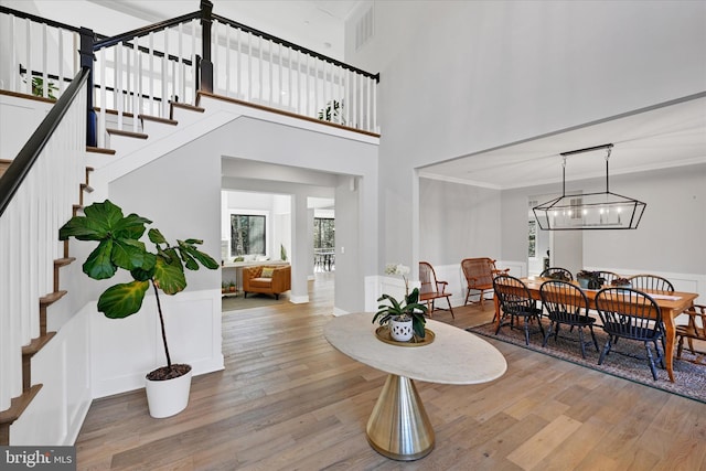 dining area featuring visible vents, crown molding, stairway, and hardwood / wood-style floors