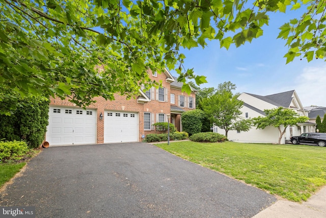18547 Kerill Rd, Triangle, VA 22172 - view of front of home featuring a front yard, asphalt driveway, brick siding, and a garage