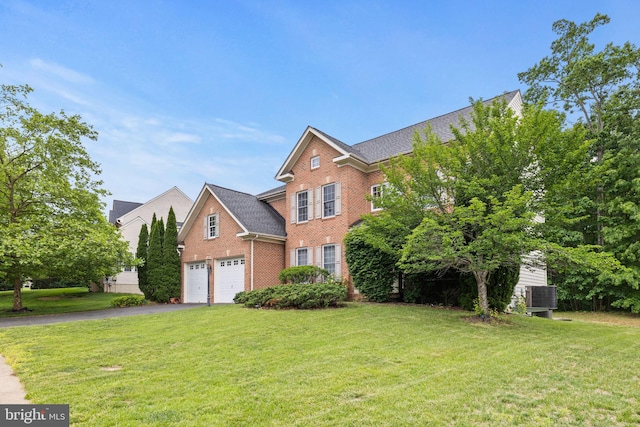 18547 Kerill Rd, Triangle, VA 22172 - view of front of home featuring brick siding, asphalt driveway, a front yard, and cooling unit