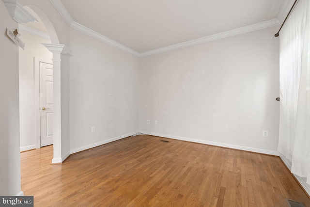 18547 Kerill Rd, Triangle, VA 22172 - spare room featuring light wood-style flooring, ornamental molding, decorative columns, arched walkways, and baseboards
