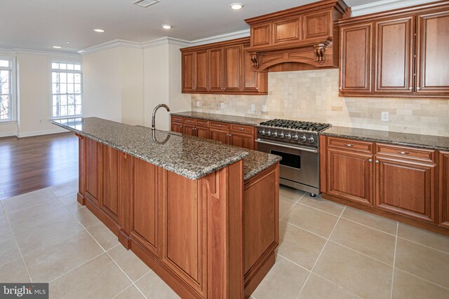 kitchen with custom range hood, brown cabinetry, ornamental molding, and stainless steel stove