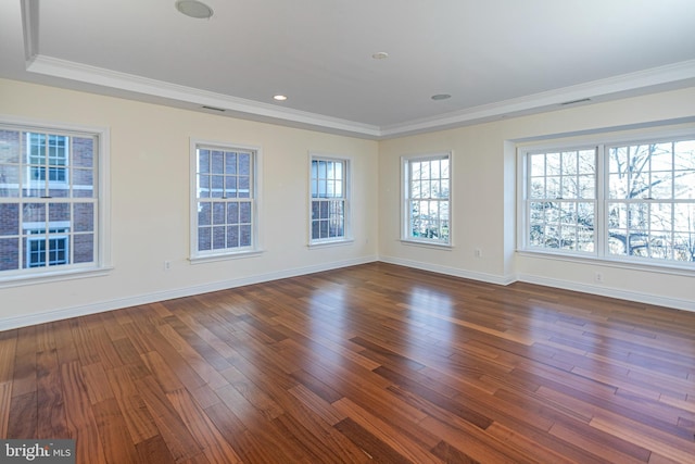 spare room with visible vents, crown molding, baseboards, and dark wood finished floors