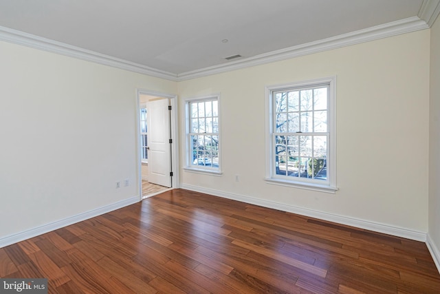 empty room with visible vents, crown molding, baseboards, and wood finished floors