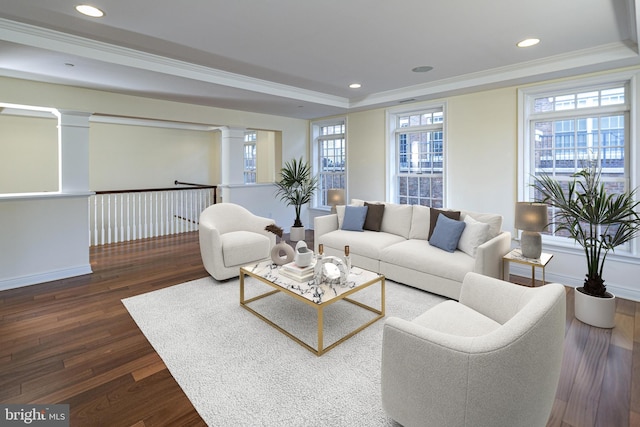 living room with crown molding, a raised ceiling, dark wood-style flooring, recessed lighting, and ornate columns