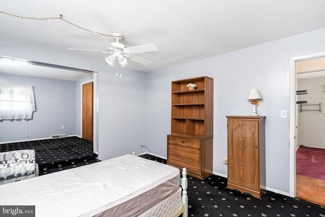 bedroom with baseboards, visible vents, dark carpet, and a ceiling fan