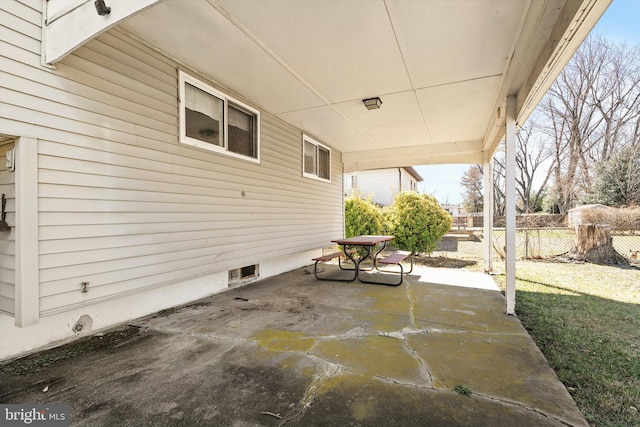 view of patio featuring an attached carport and fence