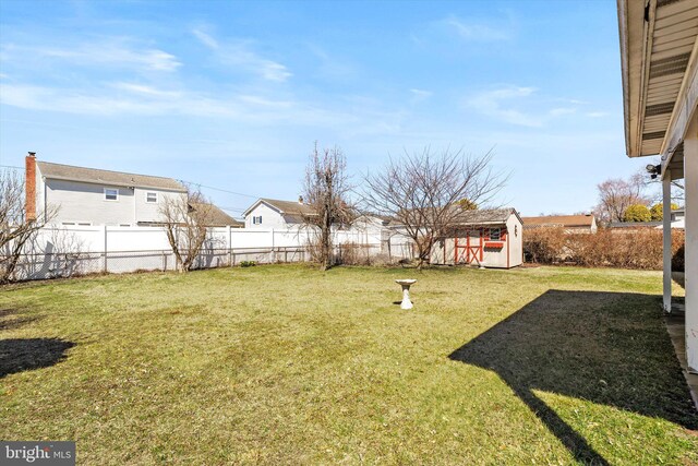 view of yard with a storage unit, a fenced backyard, and an outdoor structure