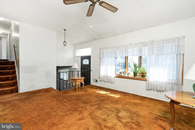 carpeted living area with lofted ceiling, stairway, and ceiling fan