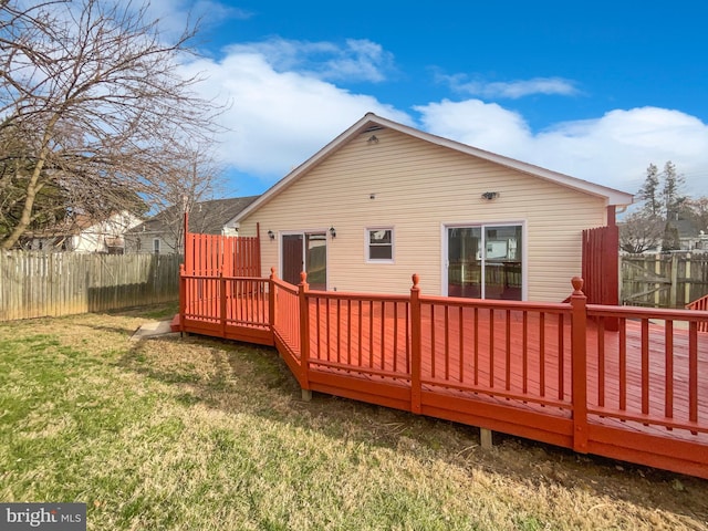 back of house with a fenced backyard, a wooden deck, and a yard