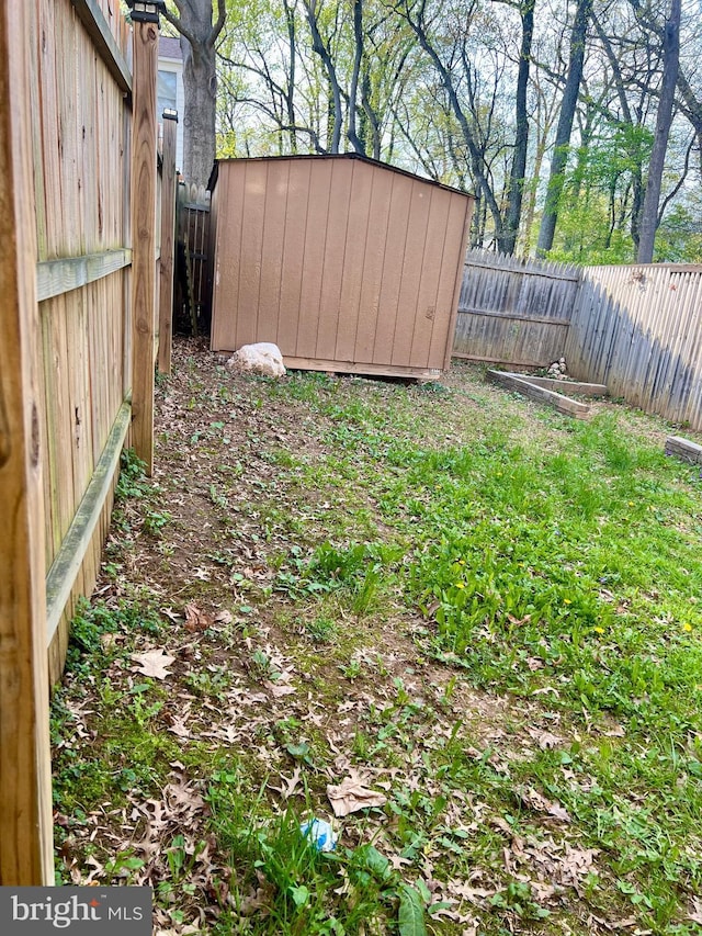 view of yard with an outdoor structure, a shed, and a fenced backyard