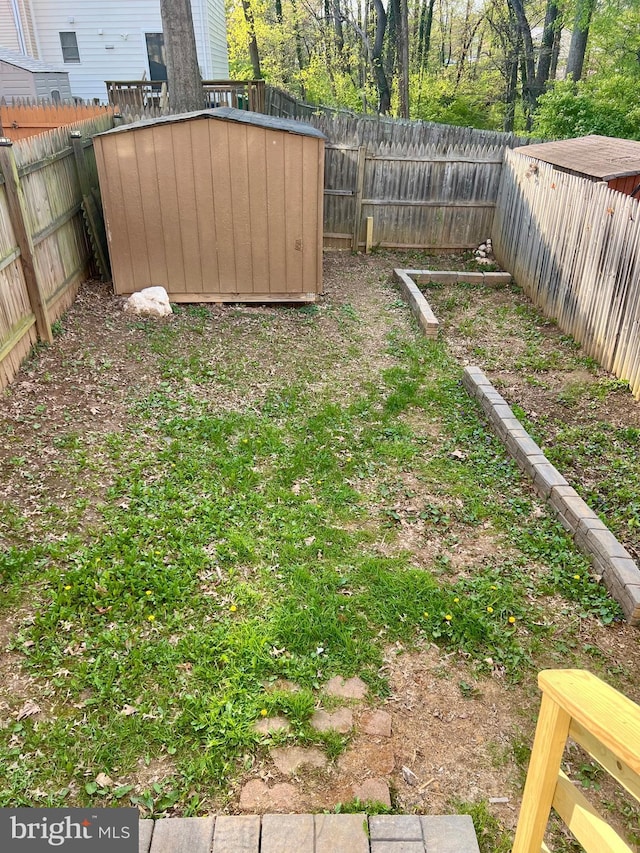 view of yard with a fenced backyard, an outdoor structure, and a shed