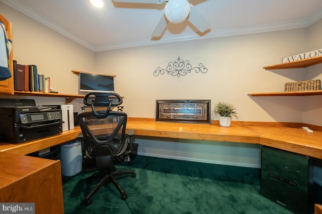 carpeted office with ceiling fan, baseboards, ornamental molding, and built in desk
