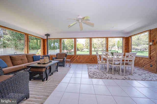 sunroom featuring wood walls, a wooden deck, and tile patterned flooring