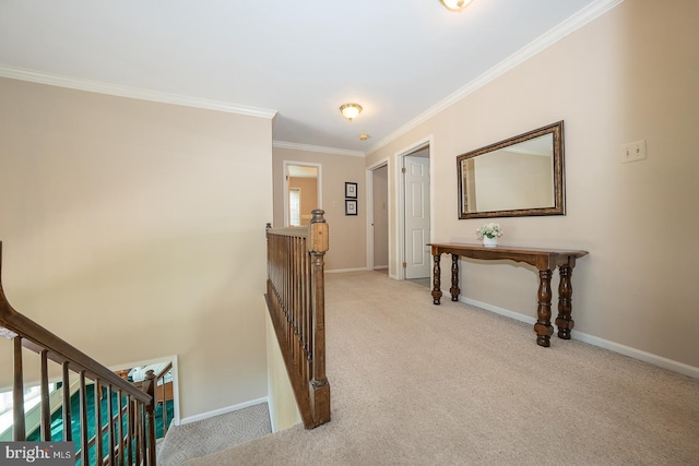 hall featuring carpet floors, ornamental molding, baseboards, and an upstairs landing