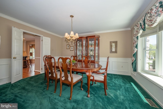 dining room featuring wainscoting, an inviting chandelier, ornamental molding, and visible vents