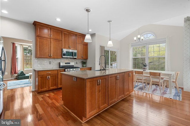 63 Woodleigh Ln, Stafford, VA 22556 - kitchen with stainless steel appliances, lofted ceiling, a sink, hardwood / wood-style floors, and brown cabinetry