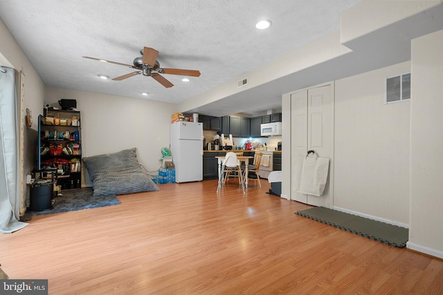 63 Woodleigh Ln, Stafford, VA 22556 - sitting room featuring light wood finished floors, visible vents, ceiling fan, and a textured ceiling