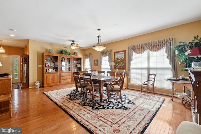 dining space featuring baseboards, ceiling fan, and light wood-style flooring
