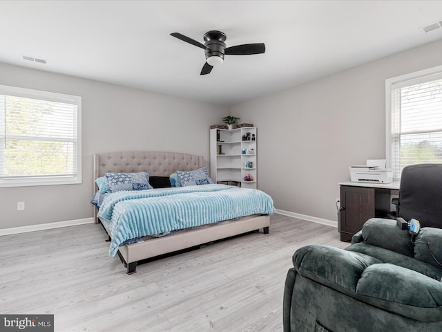 bedroom featuring visible vents, baseboards, light wood-type flooring, and a ceiling fan