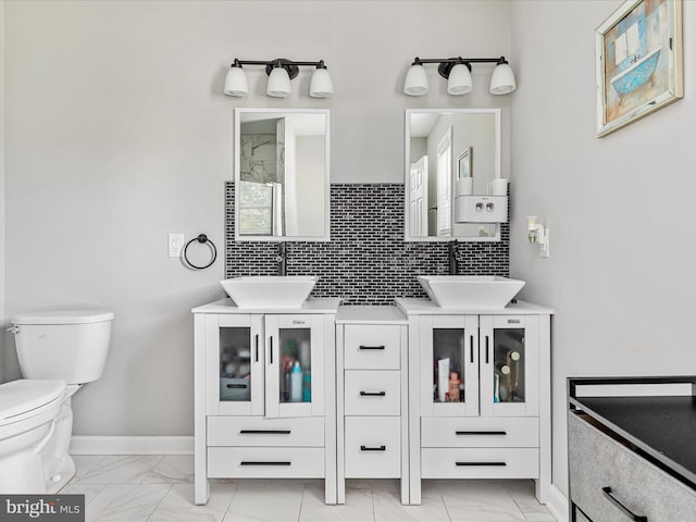 bathroom featuring tasteful backsplash, marble finish floor, baseboards, and toilet
