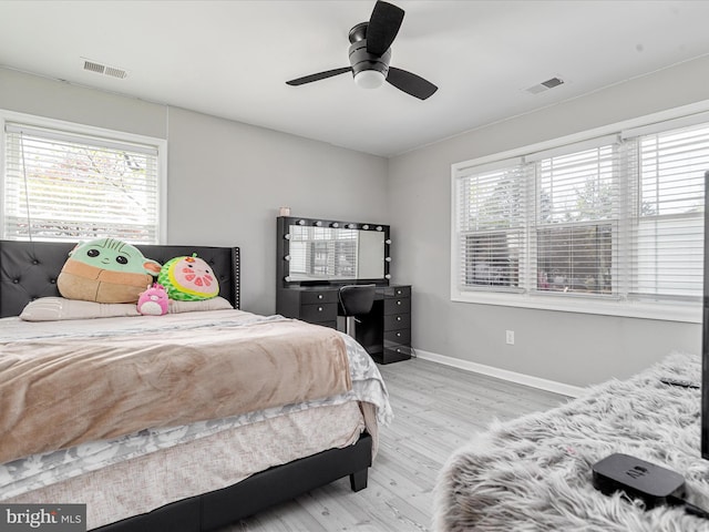 bedroom with visible vents, baseboards, a ceiling fan, and wood finished floors