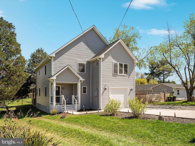 traditional-style home with a front yard, an attached garage, covered porch, and driveway