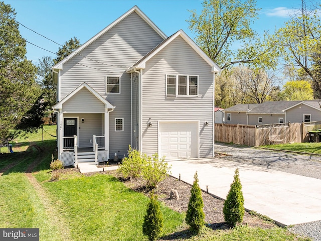traditional-style house featuring a garage, covered porch, a front yard, fence, and driveway