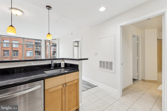kitchen featuring light tile patterned floors, a sink, dark countertops, and stainless steel dishwasher