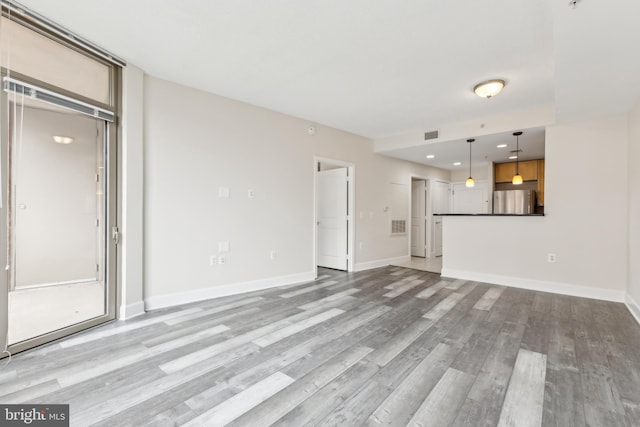 unfurnished living room with recessed lighting, visible vents, baseboards, and light wood-type flooring