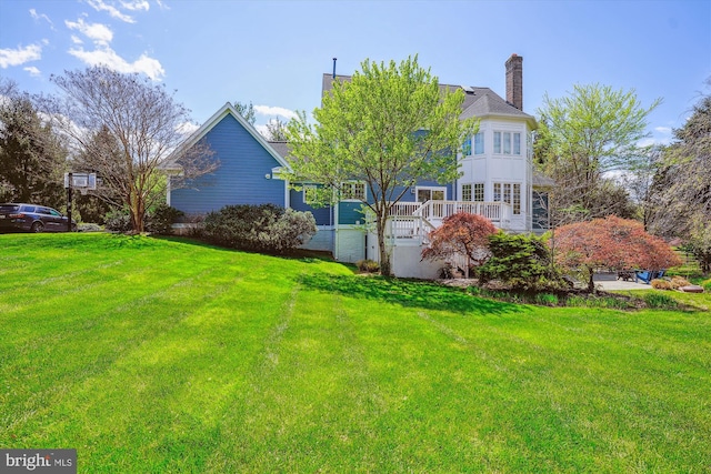 rear view of house with a lawn and a chimney