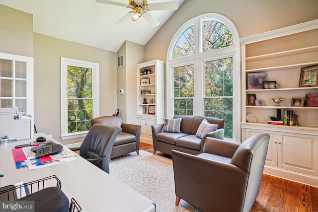 home office featuring dark wood finished floors, visible vents, a ceiling fan, and a wealth of natural light