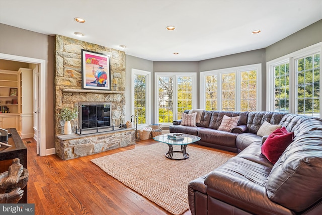 living area with a fireplace, wood finished floors, and recessed lighting