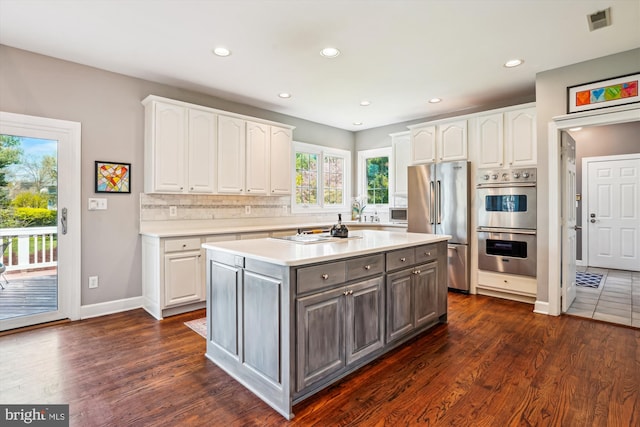 kitchen with tasteful backsplash, white cabinets, appliances with stainless steel finishes, gray cabinetry, and visible vents