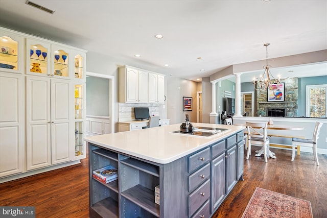 kitchen with ornate columns, white cabinetry, gray cabinetry, visible vents, and a kitchen island