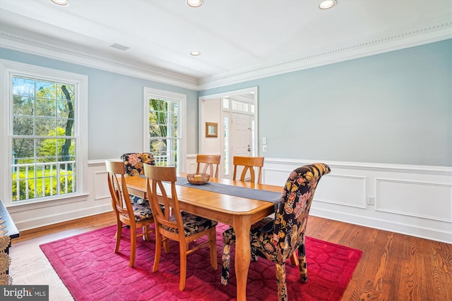 dining area featuring ornamental molding, a wainscoted wall, wood finished floors, and recessed lighting