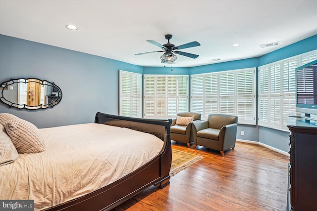 bedroom with baseboards, wood finished floors, visible vents, and recessed lighting