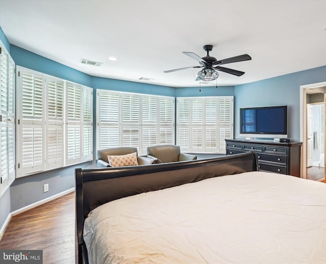 bedroom with visible vents, wood finished floors, baseboards, and a ceiling fan