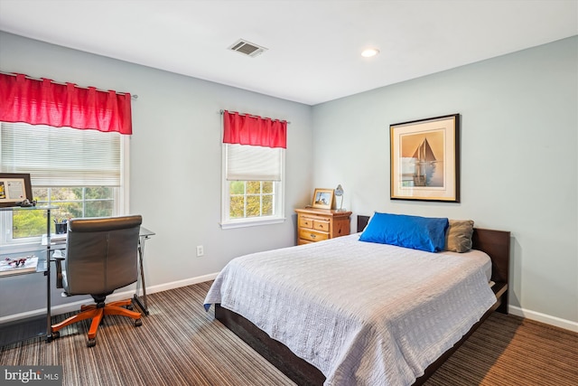 carpeted bedroom featuring baseboards, visible vents, recessed lighting, and multiple windows