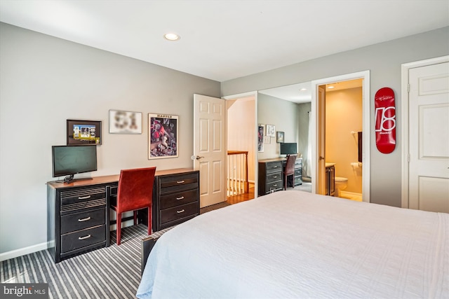 carpeted bedroom with recessed lighting, ensuite bath, and baseboards