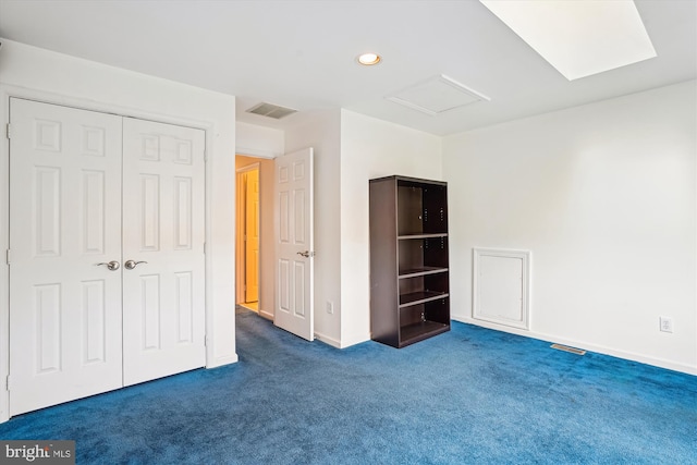 unfurnished bedroom featuring recessed lighting, dark colored carpet, visible vents, baseboards, and attic access